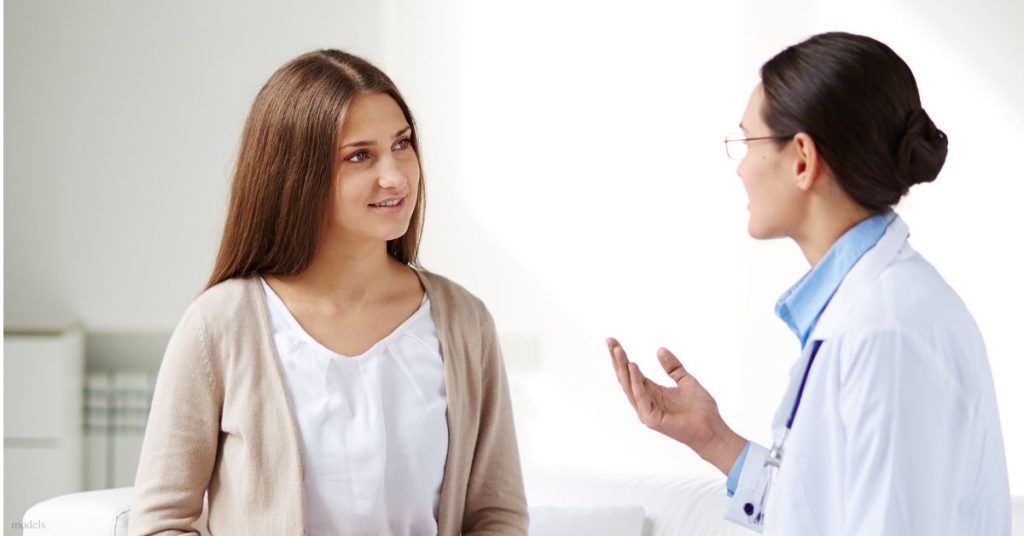 Woman speaking with a doctor at a consultation (models)