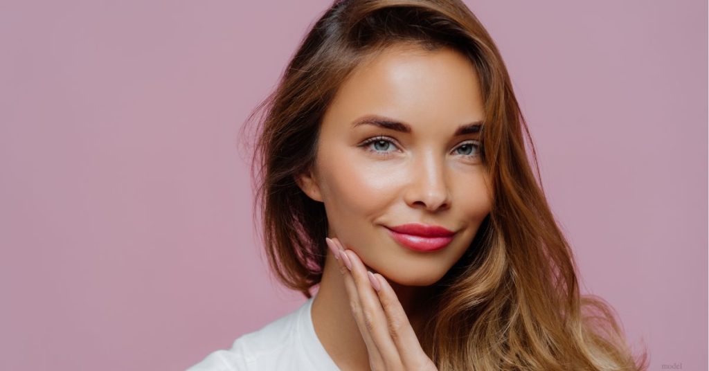 Woman with hands gently on her chin (MODEL)